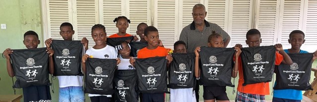 Young athletes pose with their kits from Project Lace Them Up, each carrying TASVG’s logo