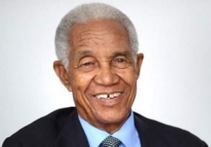Smiling portrait of Sir Garfield Sobers of Barbados in a dark suit.